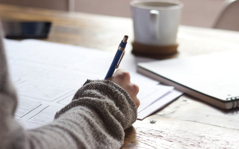 A person at a desk with a notebook, looking focused and calm — representing mental clarity and cognitive performance