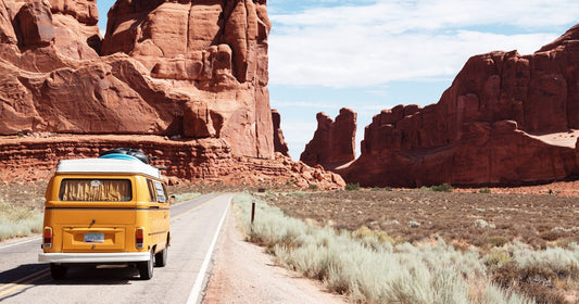 A winding open road disappearing into a calm mountain landscape — symbolic of peaceful, anxiety-free travel