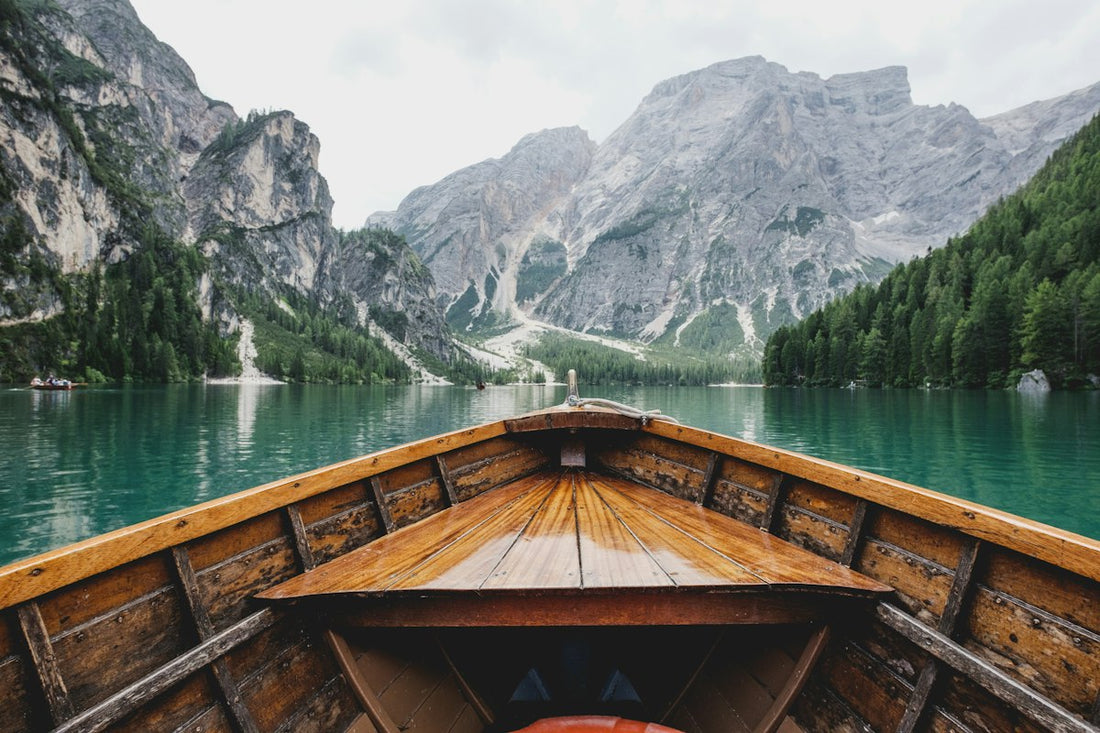 Person sitting calmly at the bow of a boat looking out over open water — representing peace and freedom from motion sickness through hypnotherapy