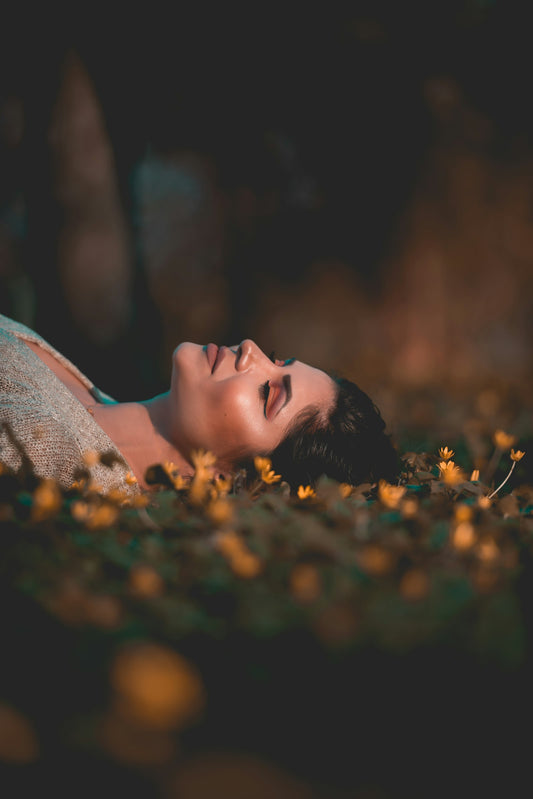 Woman resting peacefully in bed at night, representing improved sleep from hypnotherapy