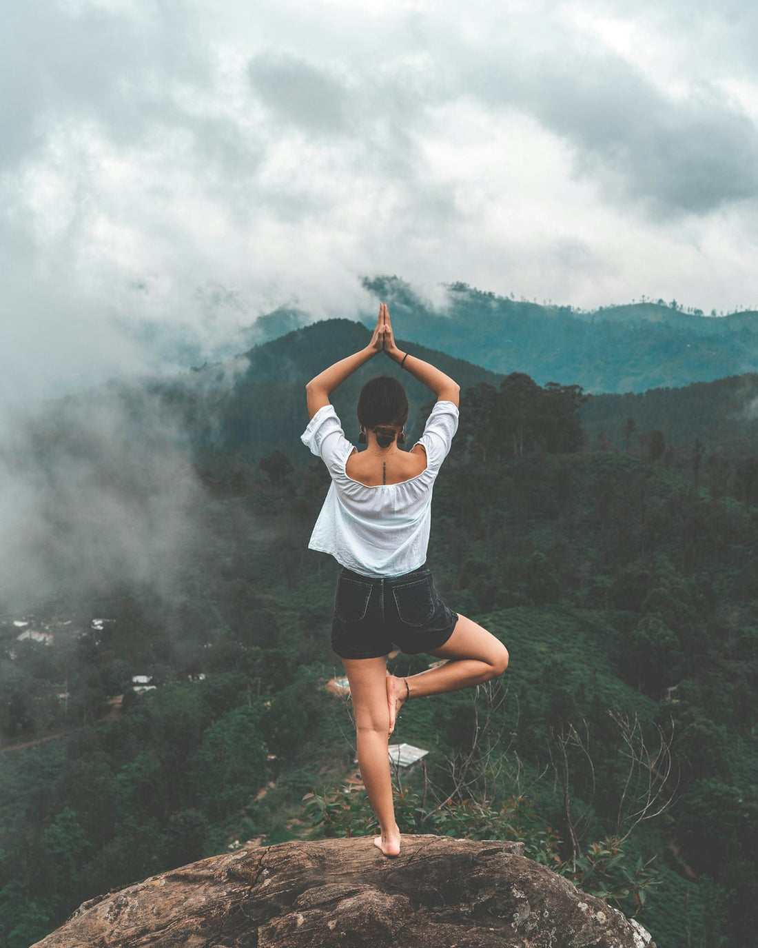 A woman standing peacefully in morning light, hands open, representing self-acceptance and positive body image